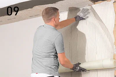 Using the smoother, integrate reinforcement fabric in the reinforcing mortar using overlapping, crease-free vertical strokes.