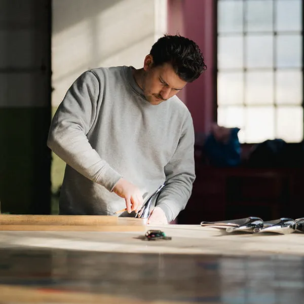Marius screws the table legs to the batten