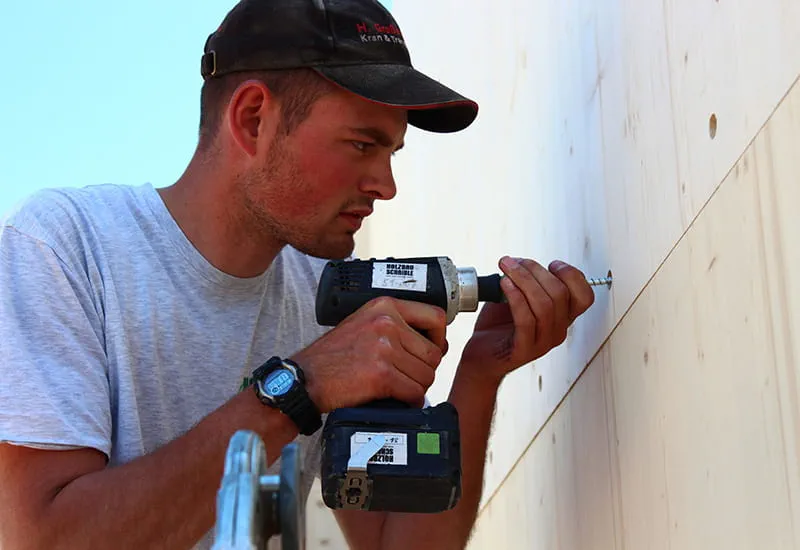 A carpenter screws some wall elements with the cordless dril DRC 18/4 from Festool.